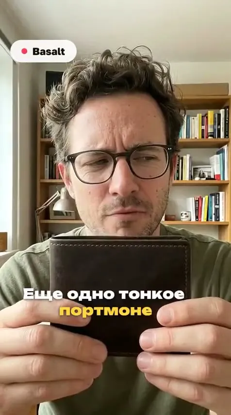 Кадр UGC-ролика: человек держит тонкое кожаное портмоне, субтитры внизу кадра